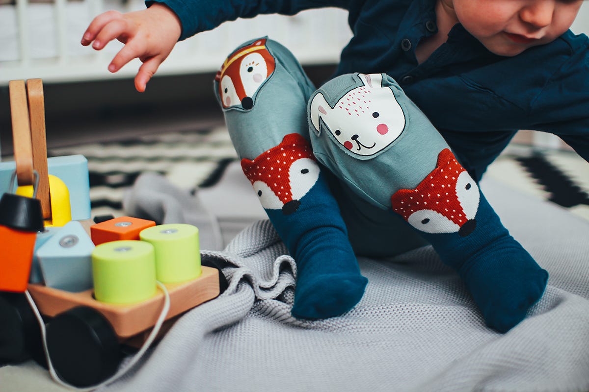 A child playing with their toys on the floor