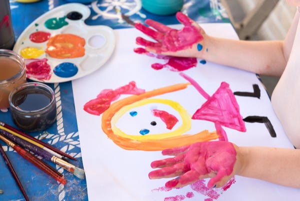 Child hand painting colourful picture