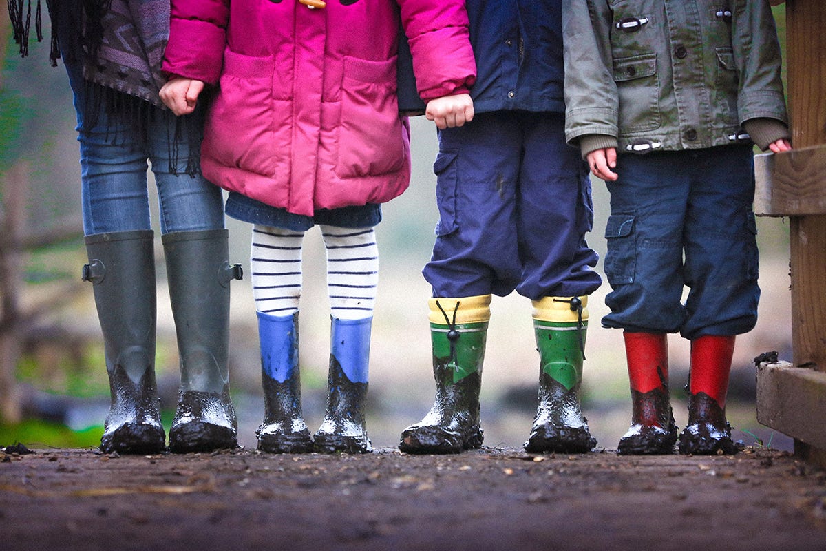 Children stood in a line wearing wellies