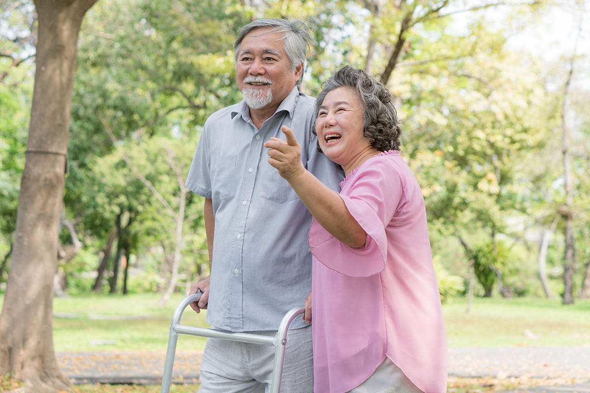 Couple walking outside with walking aid