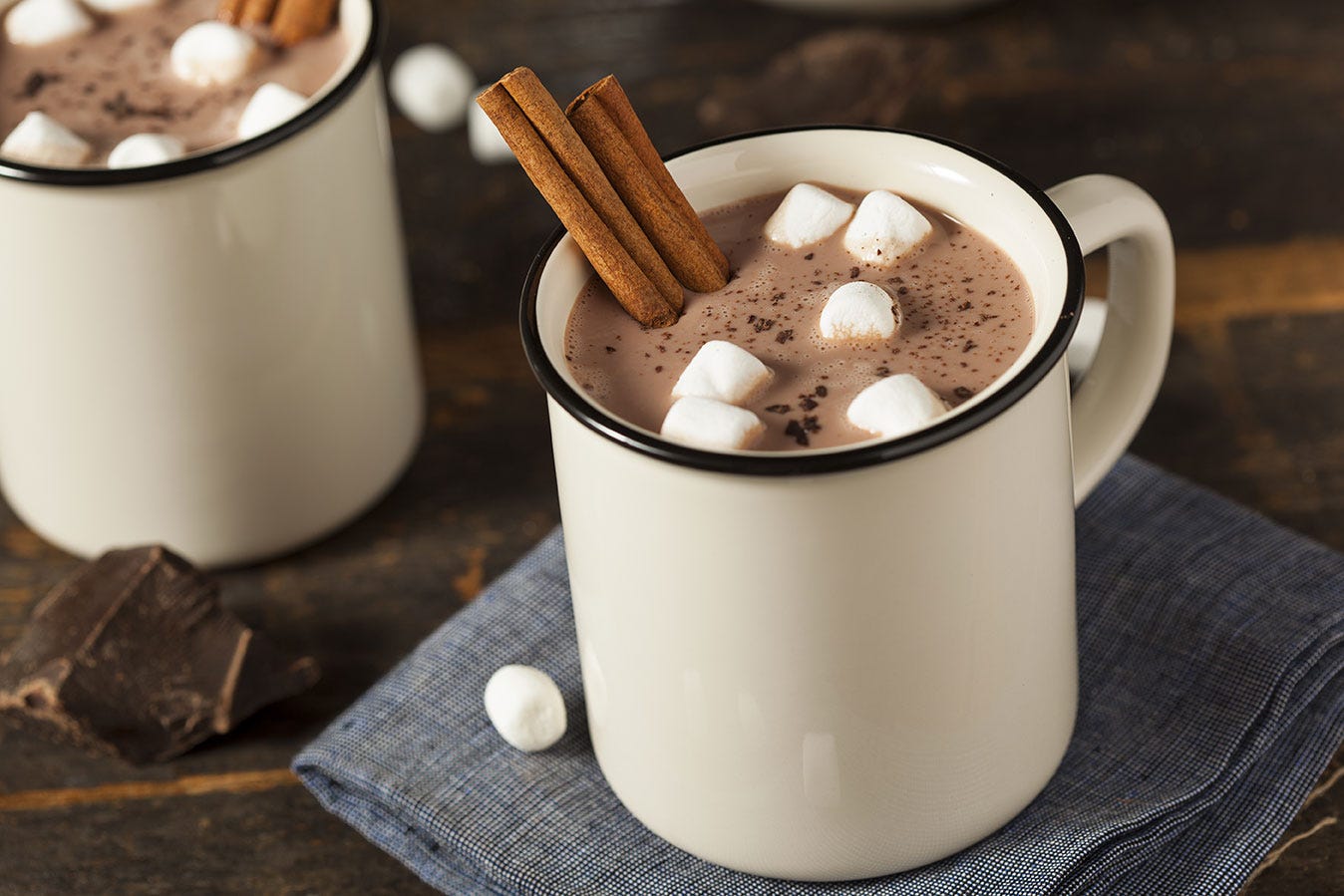 Mug of hot chocolate with mini marshmallows and cinnamon stick