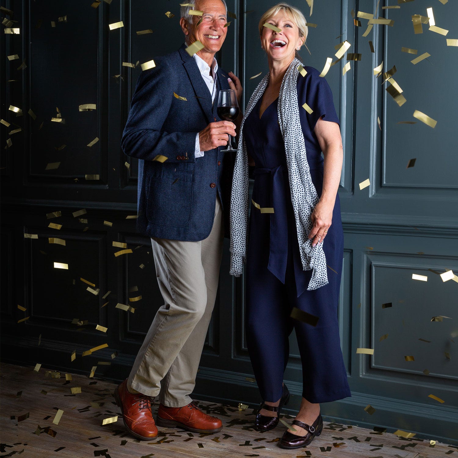 Man and woman dressed up with confetti falling around them