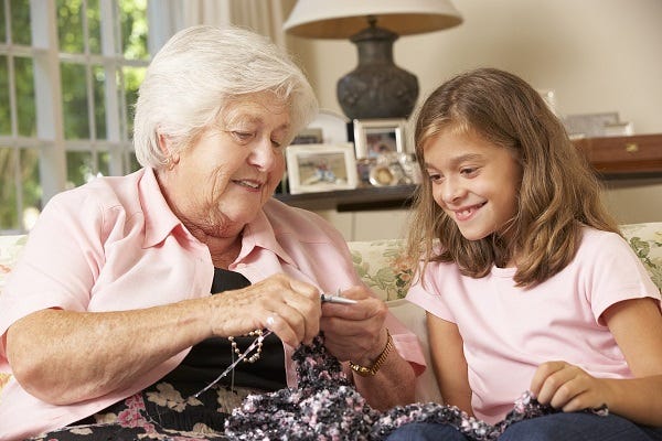 Older lady knitting with child