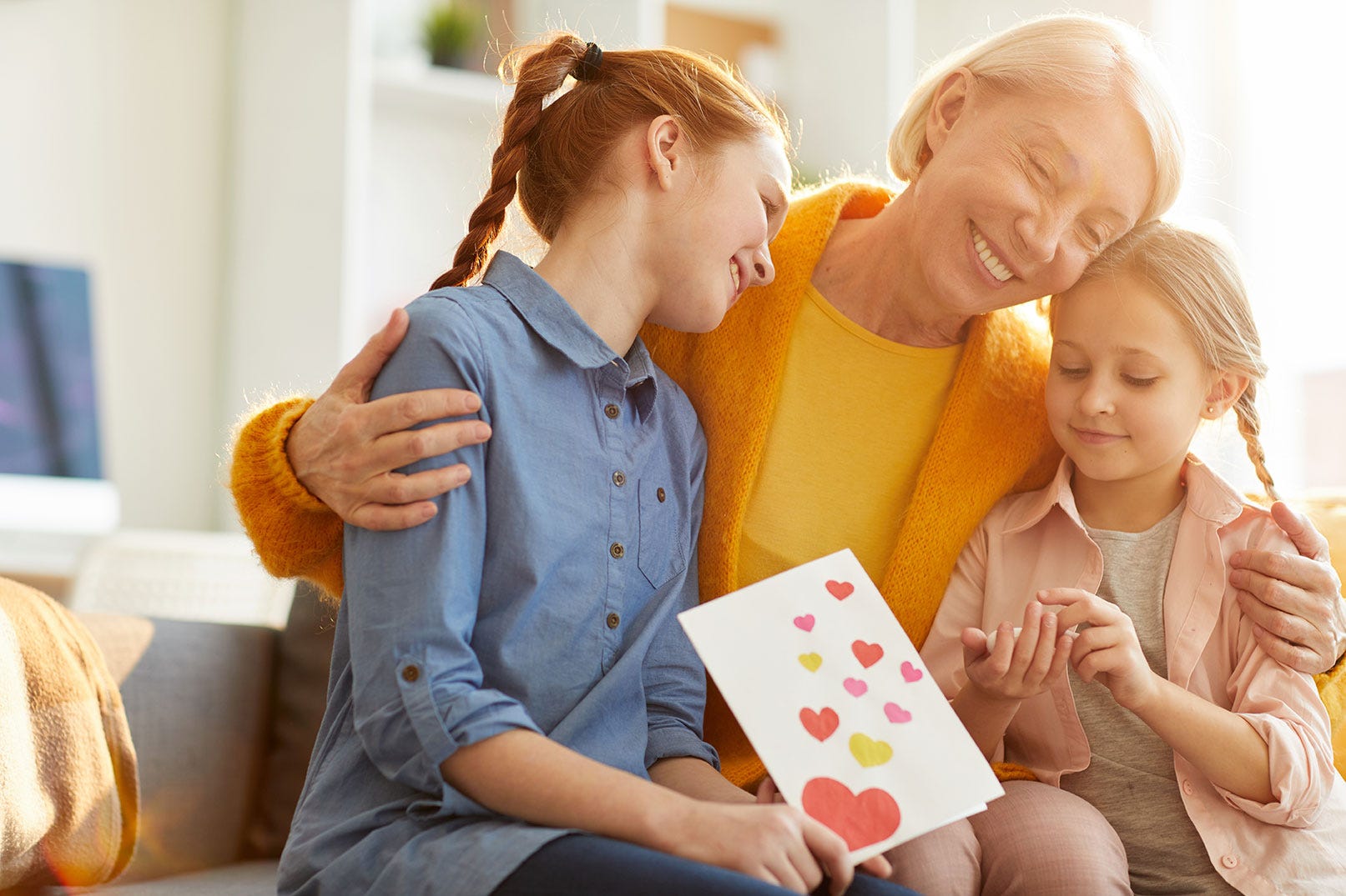 Girls gifting grandmother a card